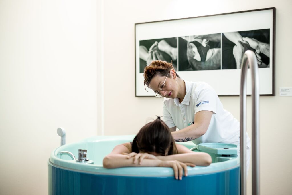 Hebamme unterstützt bei Wassergeburt