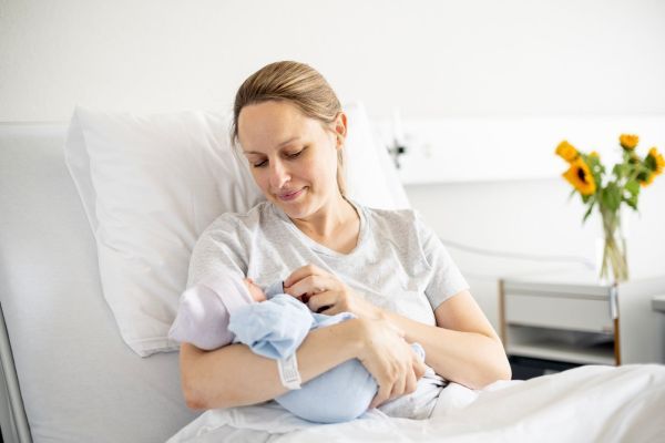 Frau im Wochenbett mit Baby