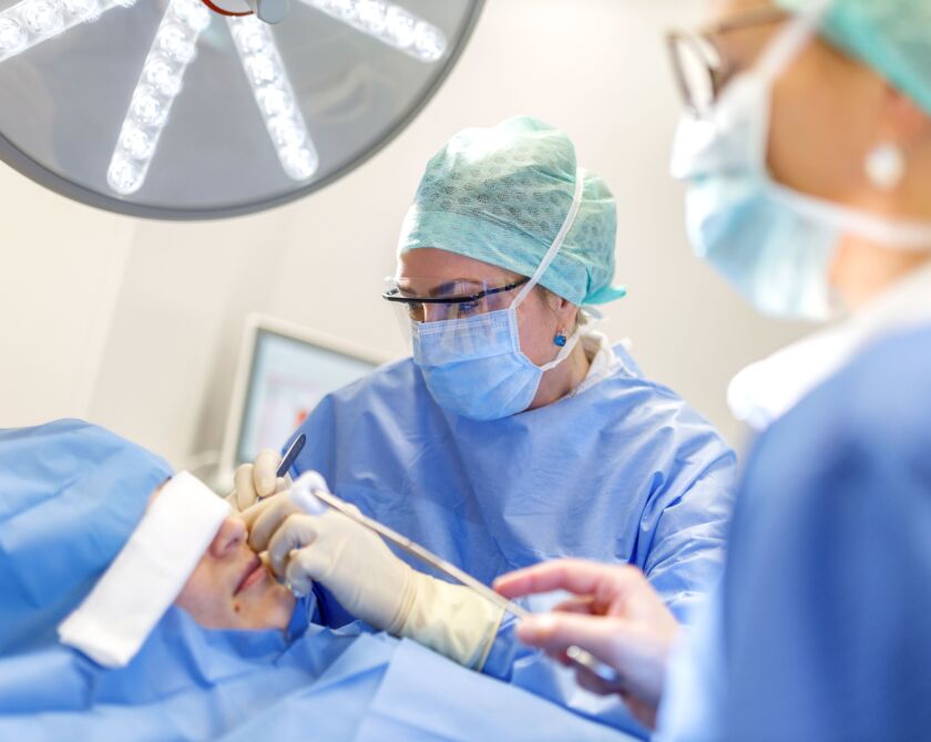 Zwei Chirurgen führen eine Nasenoperation an einem Patienten durch