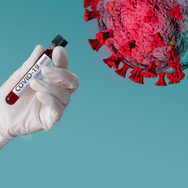 Illustration zeigt das Corona-Virus mit einer Blutampulle