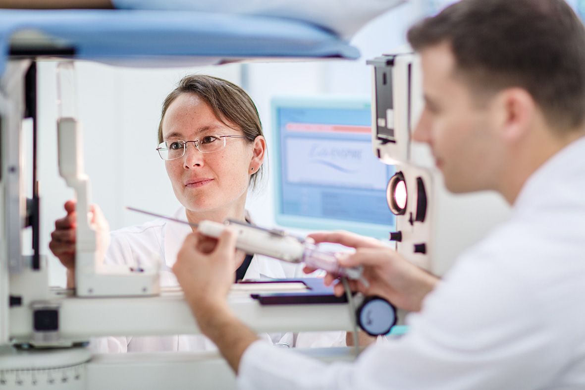 A doctor and a female doctor look at a device together