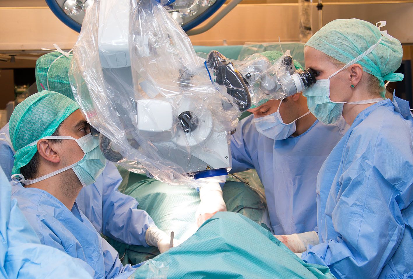 Drei Chirurgen und eine Chirurgin führen eine Brustoperation durch