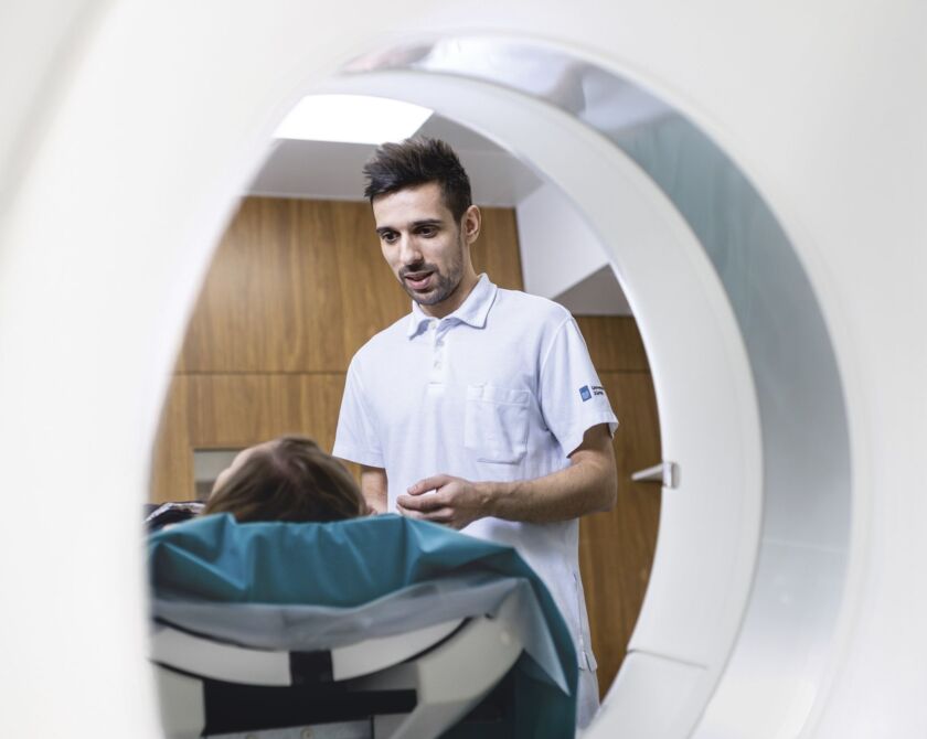 Ein Arzt erklärt einer Patientin die Funktion eines MRI