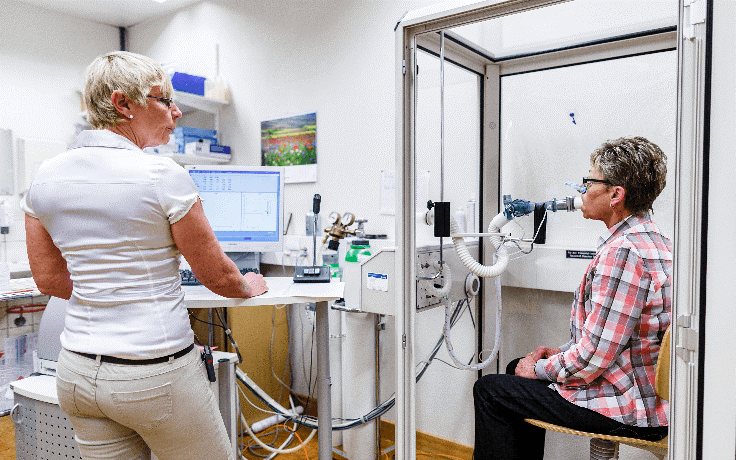 A doctor performs a pulmonary function test on a patient