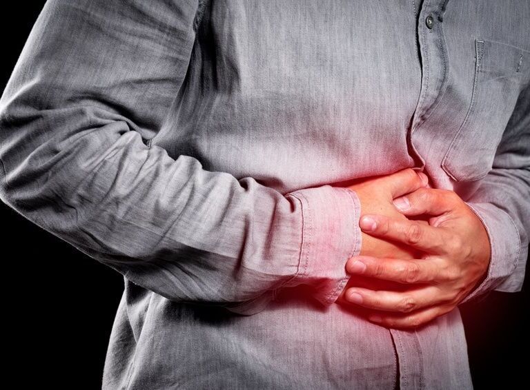 Mann hält seine Hände auf den Bauch