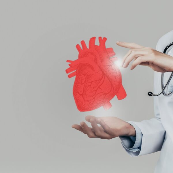 Arzt hält Symbol-Herz zwischen den Händen