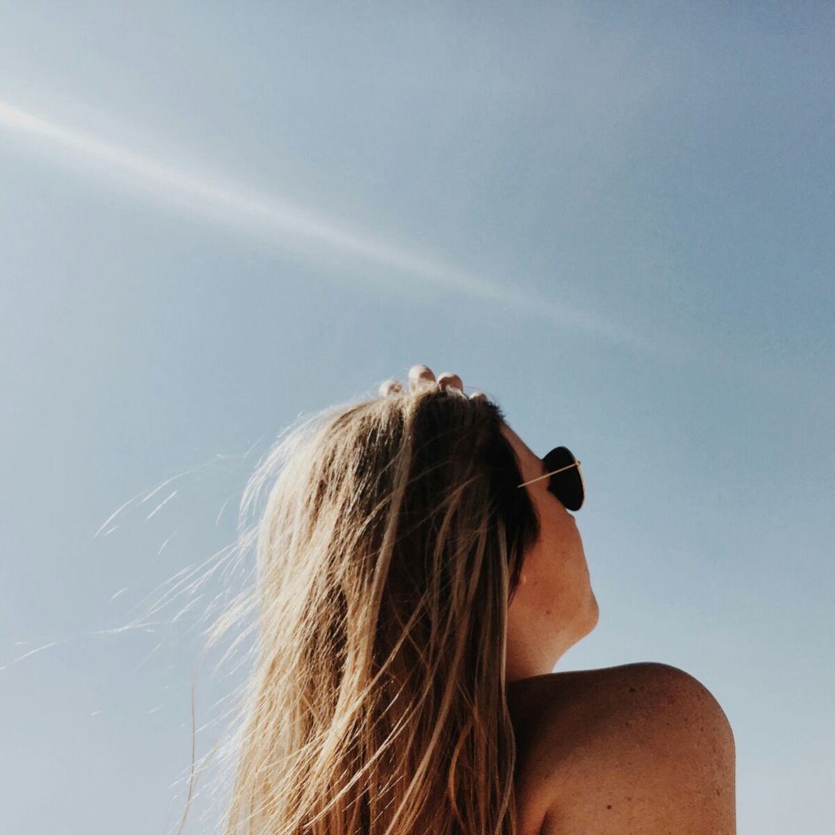 Frau mit Sonnenbrille sonnt sich