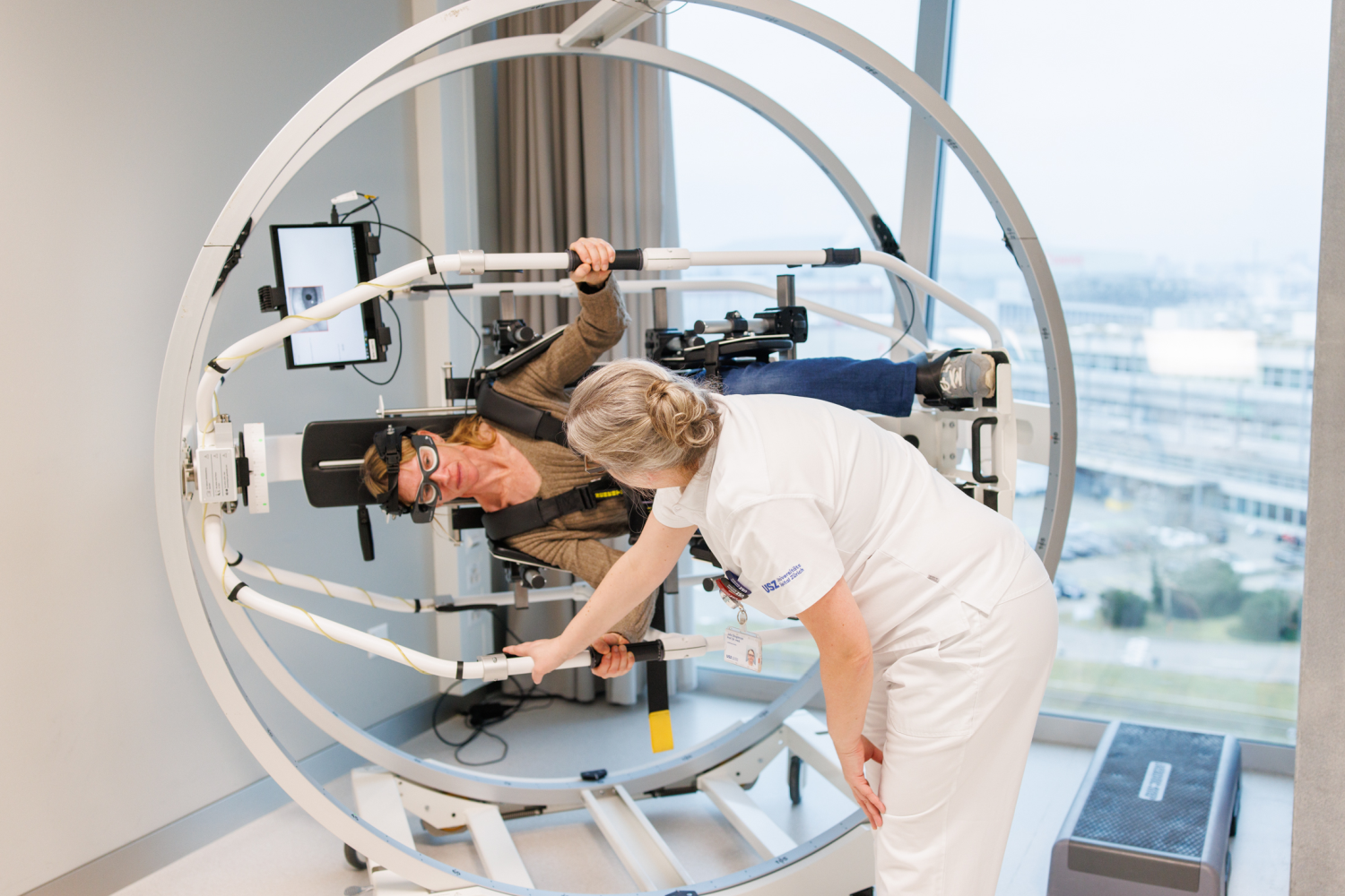 Patientin sitzt im Drehstuhl und wird von Ärztin betreut