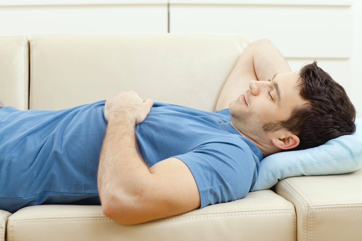 Mann schläft auf Sofa