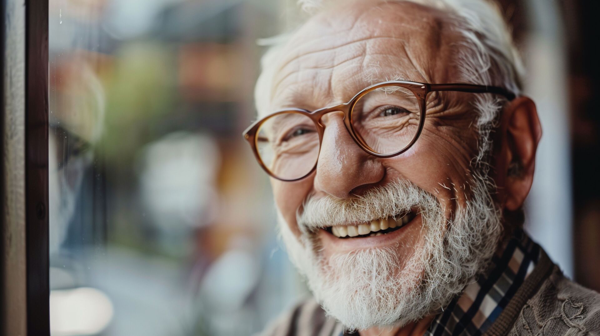 Ein älterer Mann mit Brille und weissem Vollbart lächelt in die Kamera