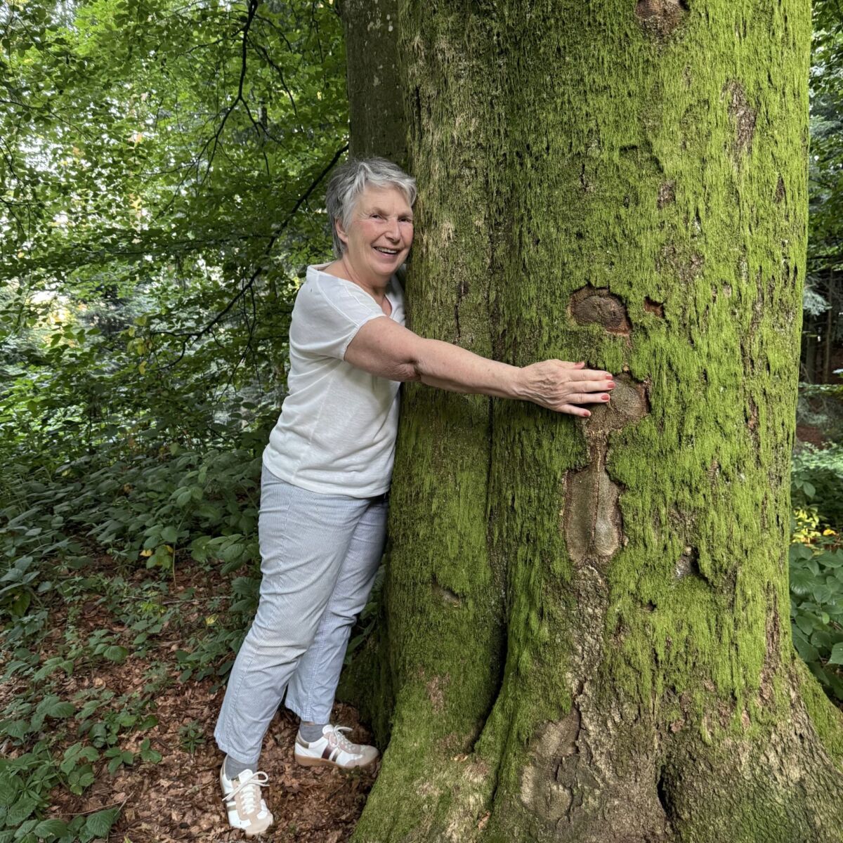 Gisela Bentele umarmt einen Baum