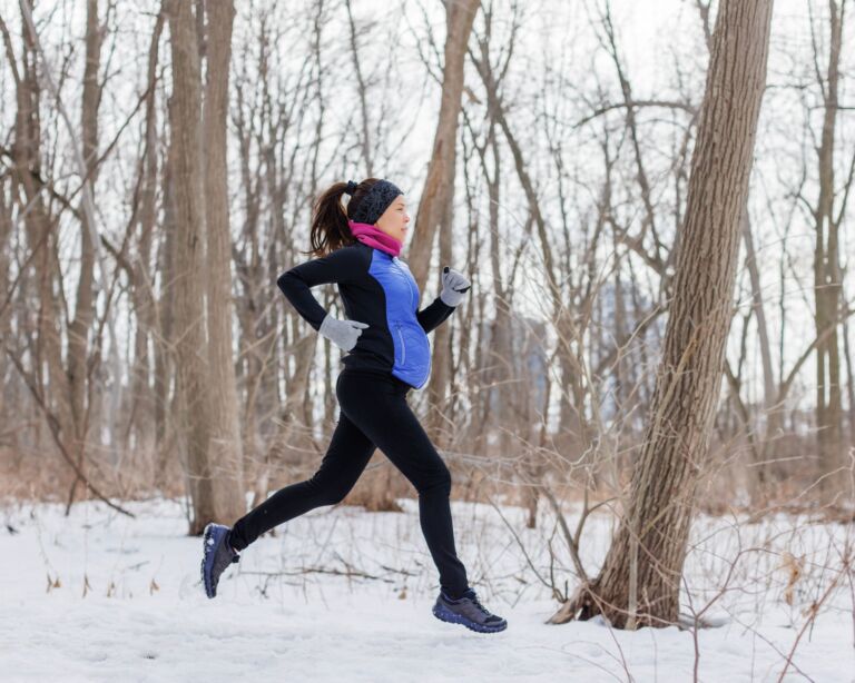 Eine Schwangere beim Joggen im Wald