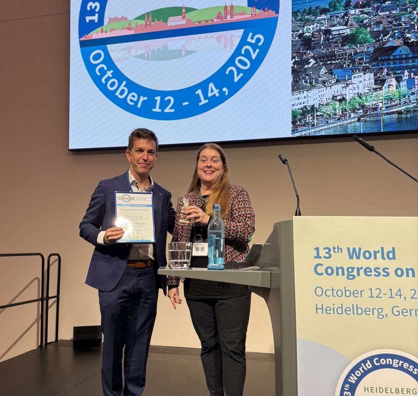 Dr. Kremer erhält Award und lächelt in die Kamera.