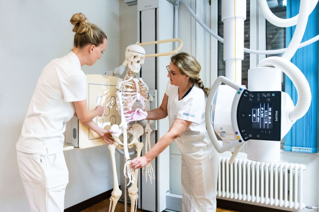Radiologiefachfrauen arbeiten an einer Skelett-Puppe.