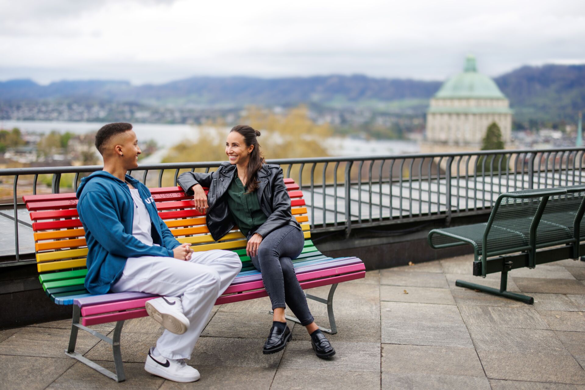 Zwei Personen sitzen auf einer Holzbank.