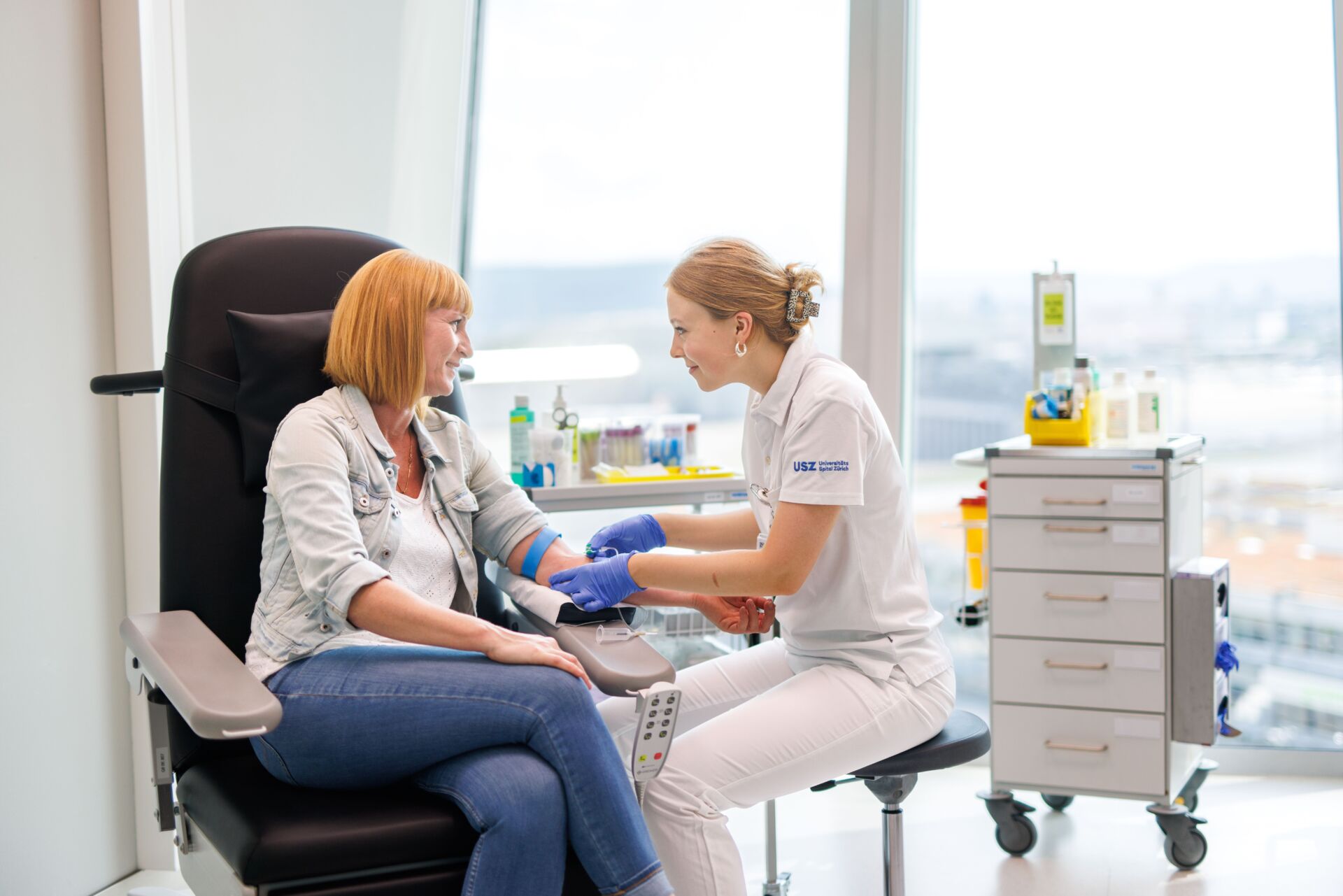 Eine Lernende nimmt einer Patientin Blut ab.