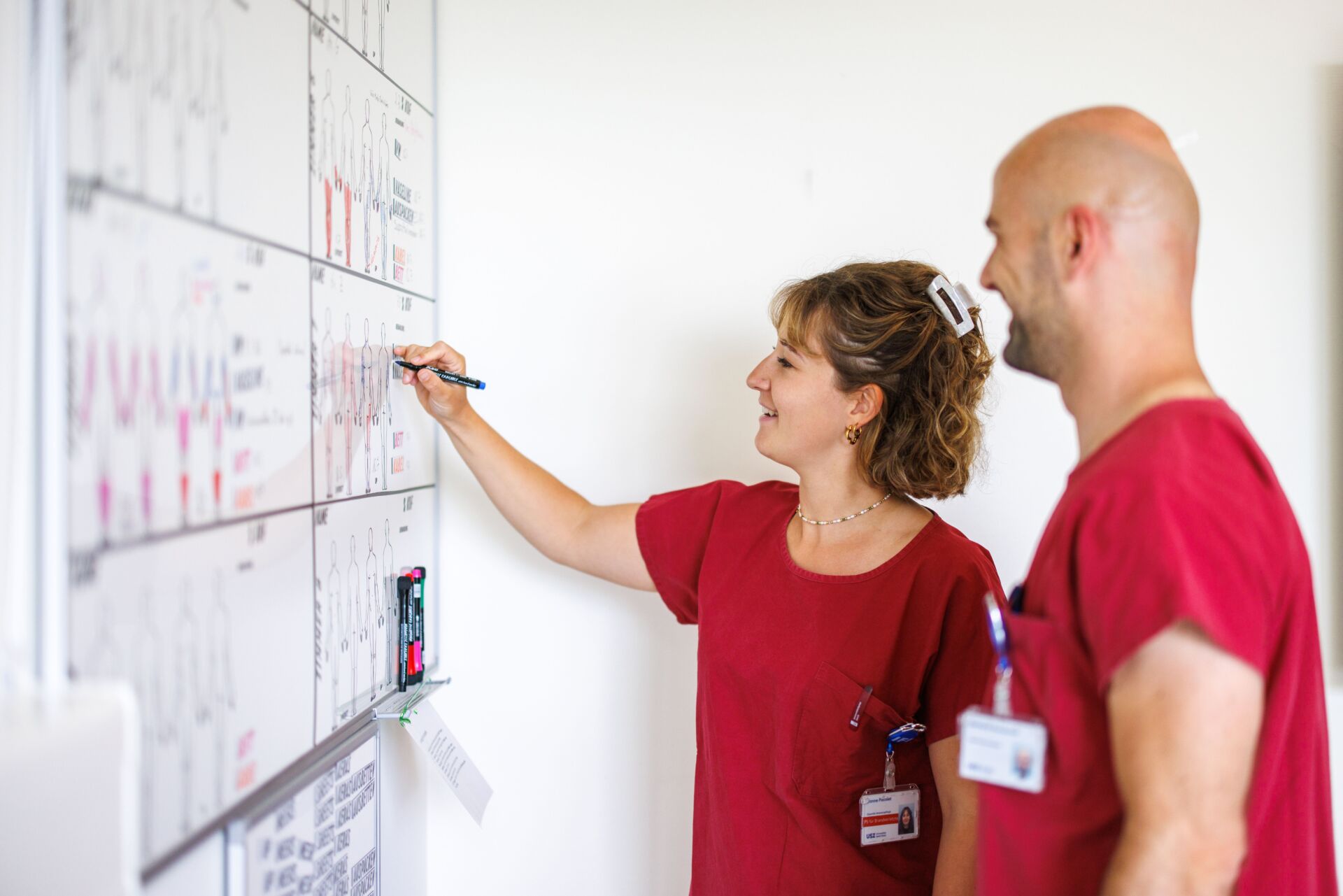 Zwei Pflegende besprechen an der Tafel.