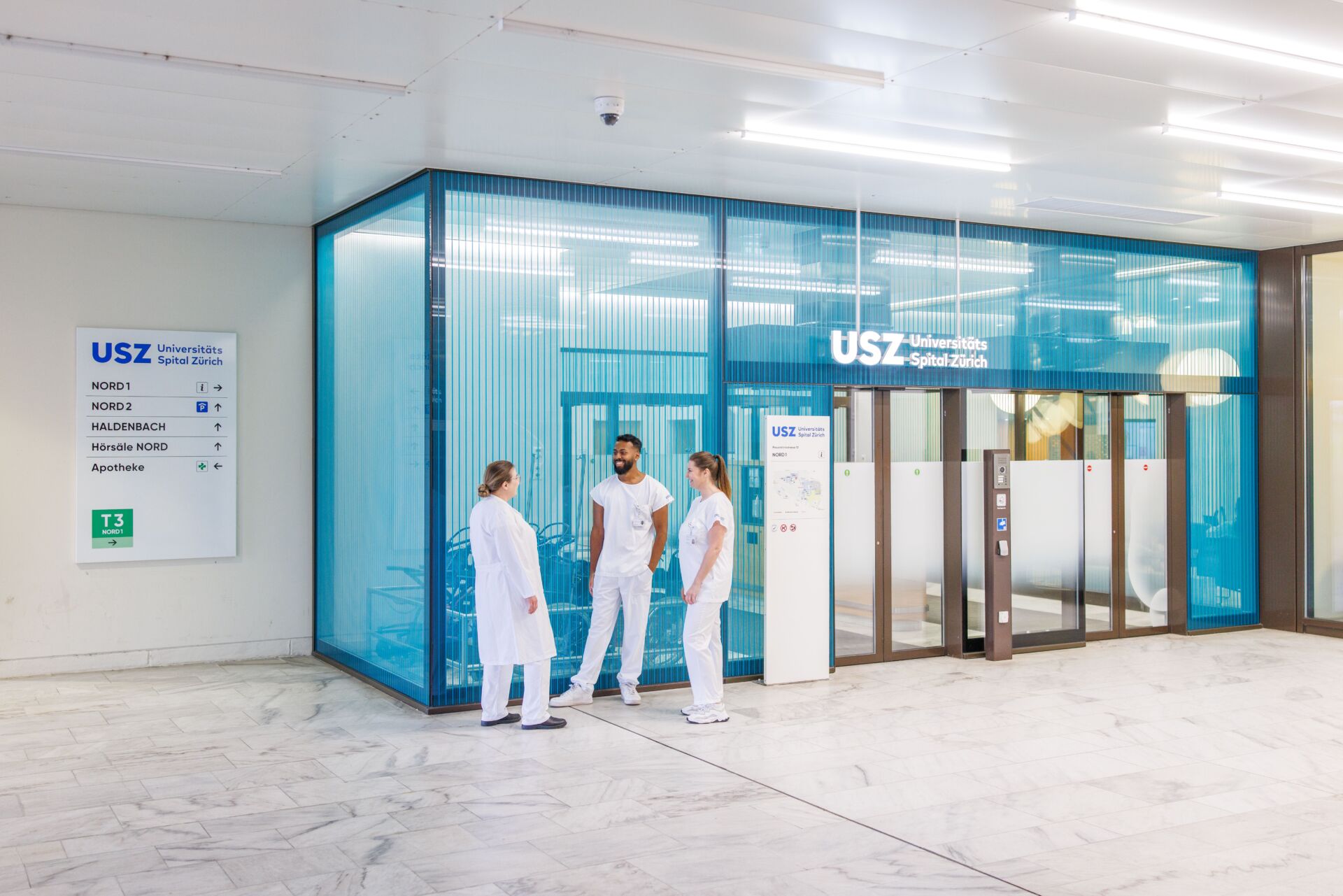 Mitarbeitende vor dem Eingang.