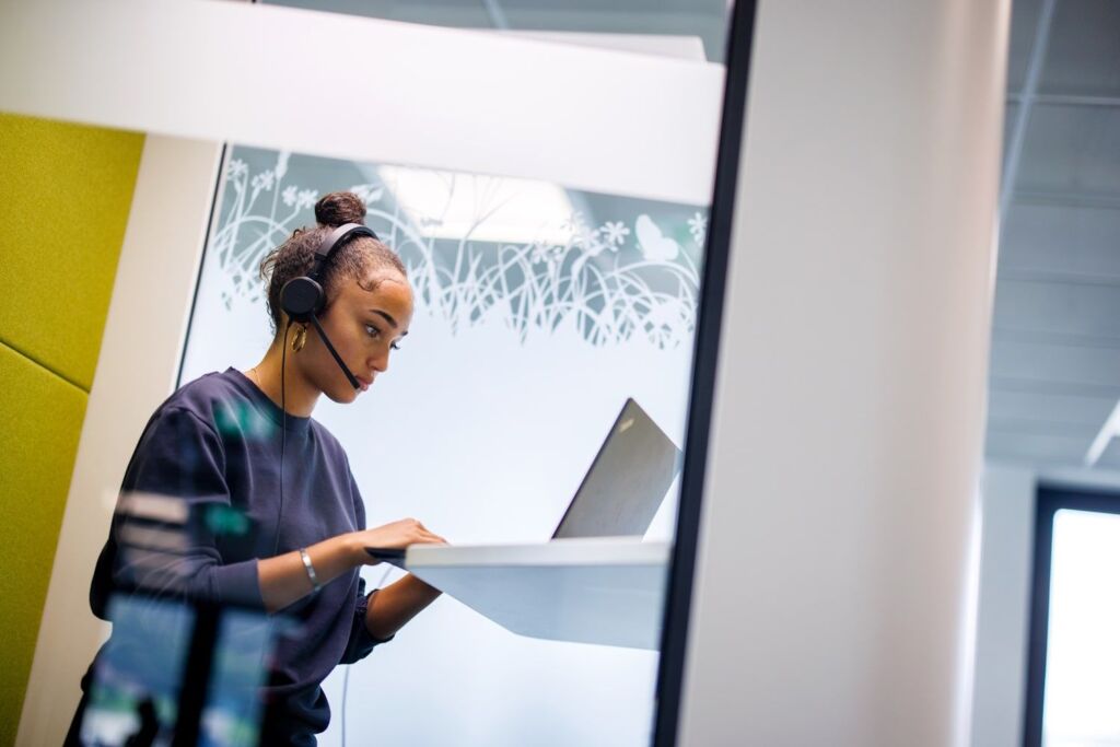 Lernende im Büro am PC mit Kopfhörer