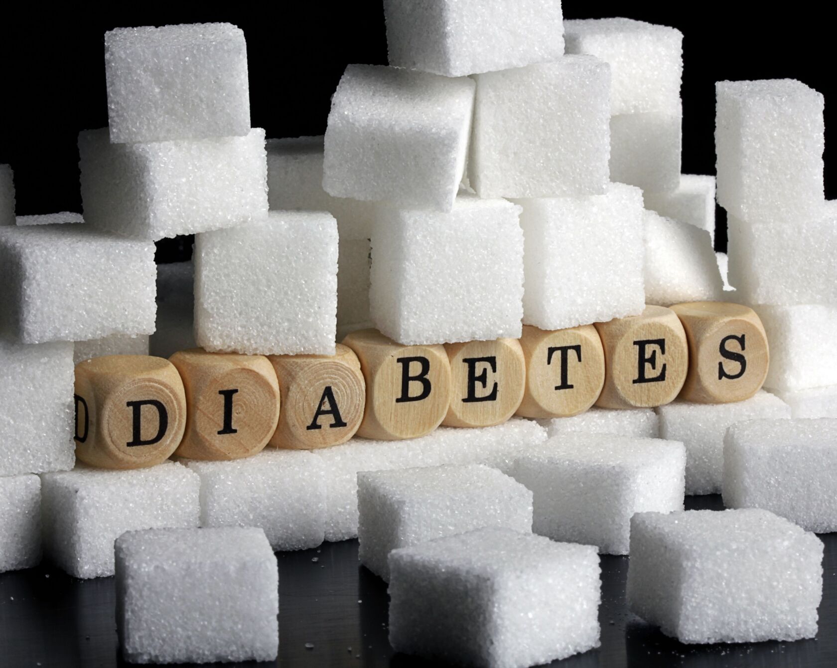 Zuckerwürfel gehäuft und Diabetes als Wort in Würfeln
