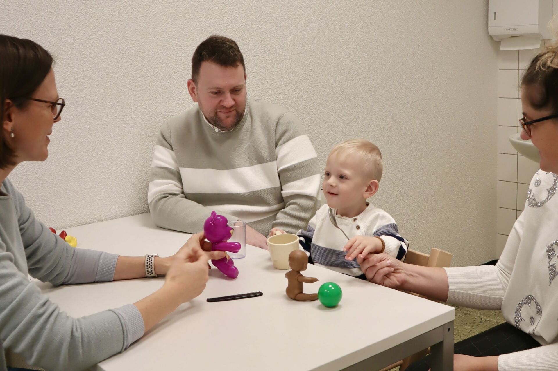 Kleinkind mit Eltern und Ärztin am Spielen