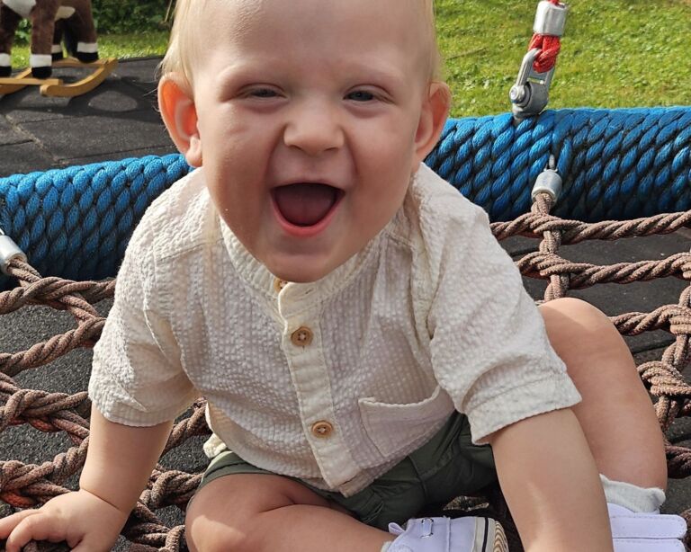 Lachendes Kleinkind auf der Schaukel