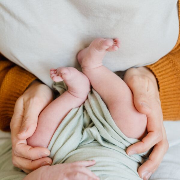 Mutter hällt die Füsse ihres Babys.
