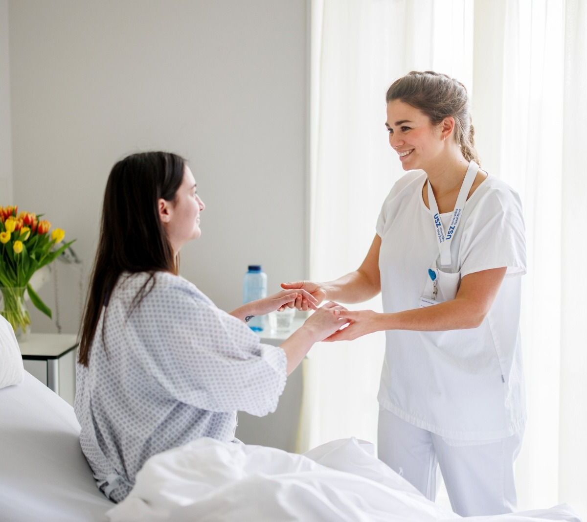 Pflegefachperson hilft Patientin beim Aufstehen