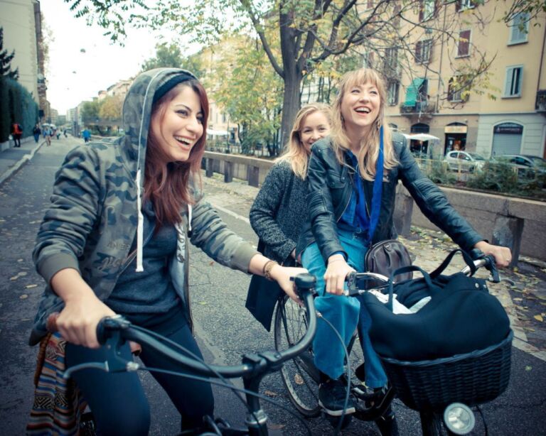 Drei junge Frauen mit Fahrrad unterwegs