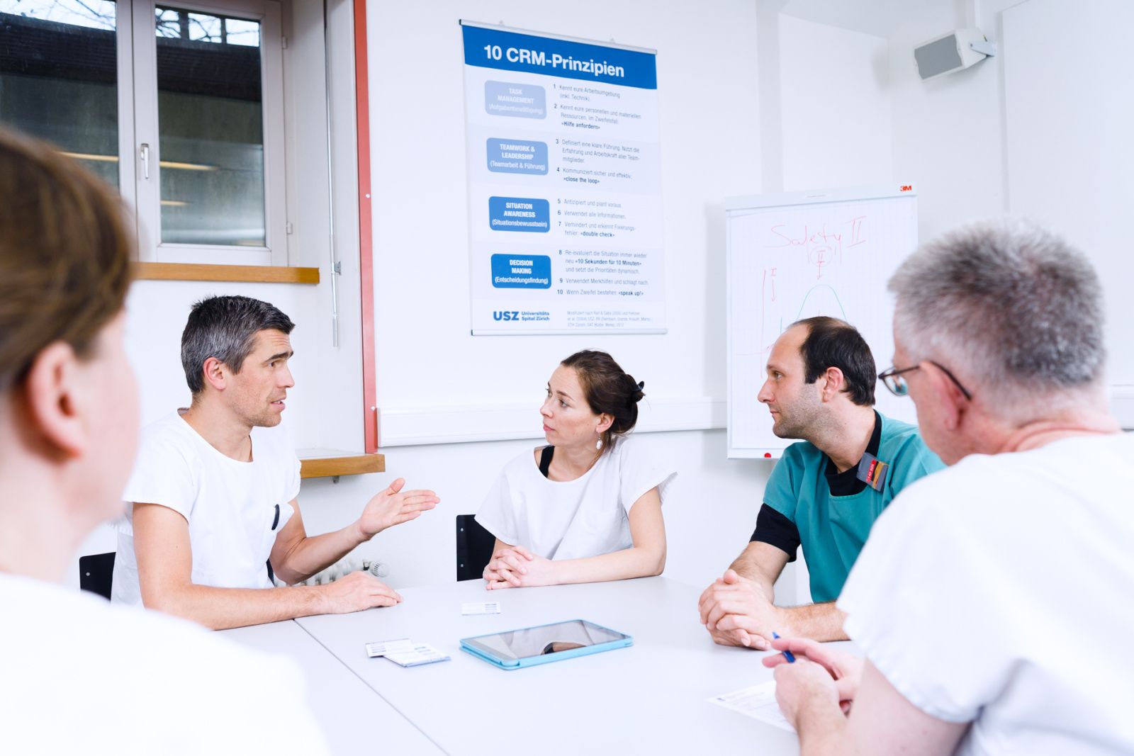 Mitarbeitende diskutieren am Tisch