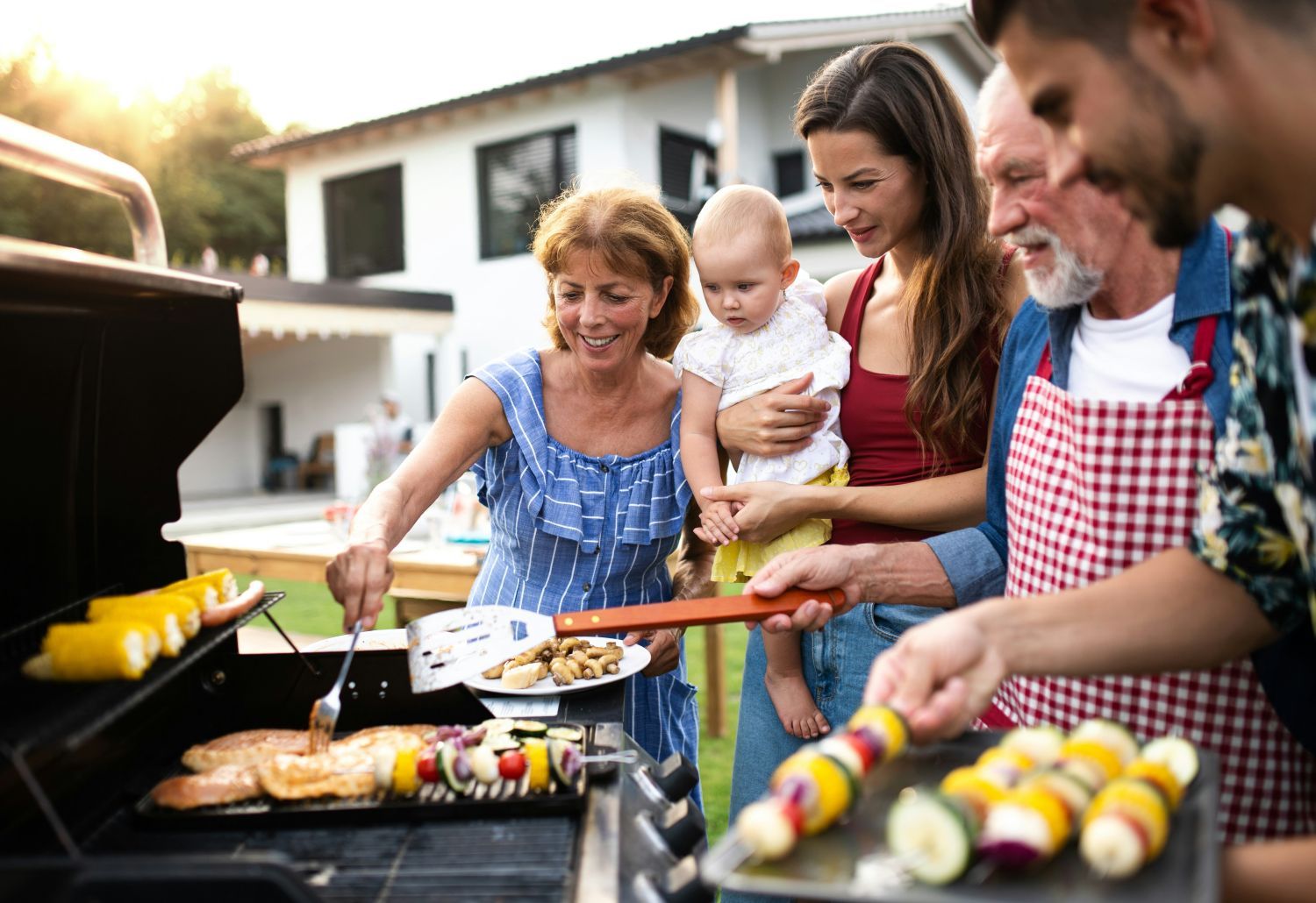 Familie steht um Grill