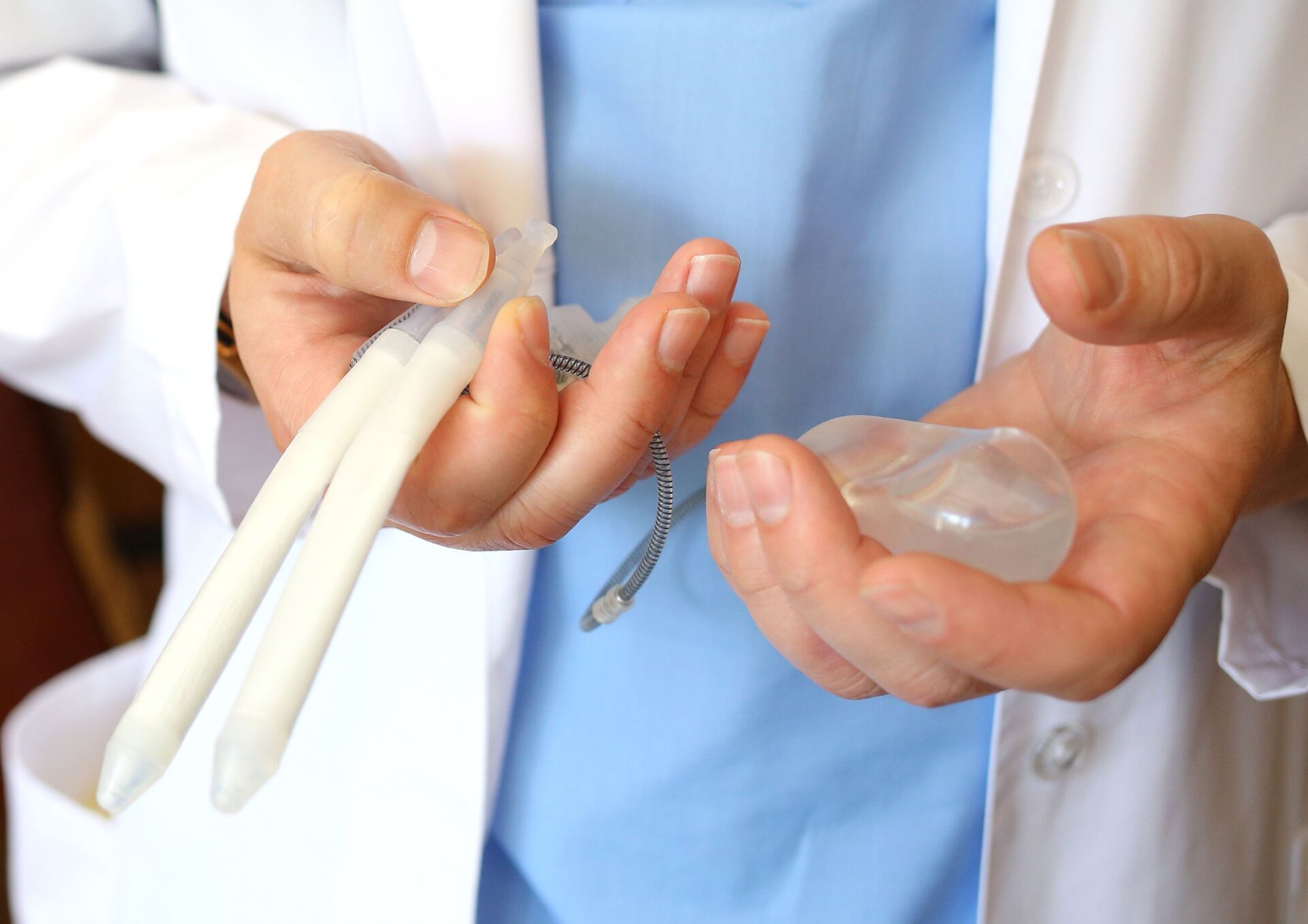 Ein Arzt hält das Implantant einer Penisprothese in der Hand.
