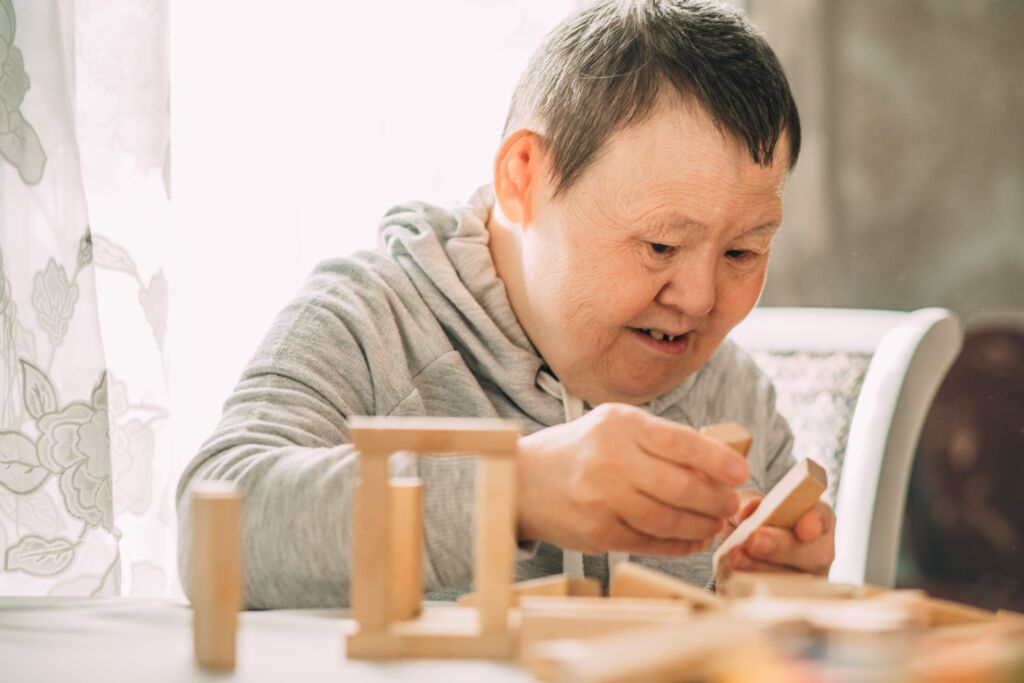 Patient mit Trisomie 21 beim Spielen.