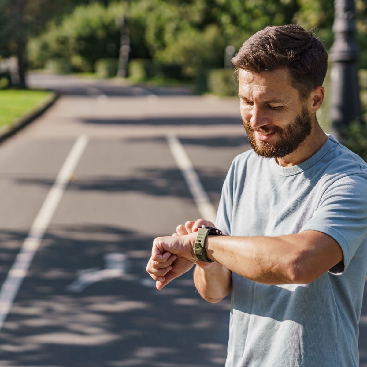 Männlicher Sportler überprüft seine Smartwatch.