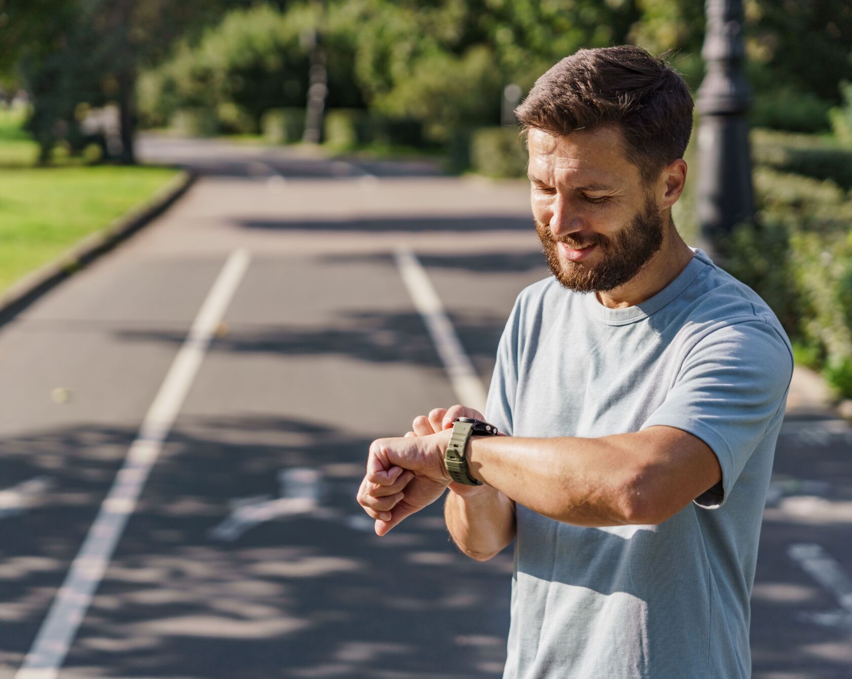 Männlicher Sportler überprüft seine Smartwatch.