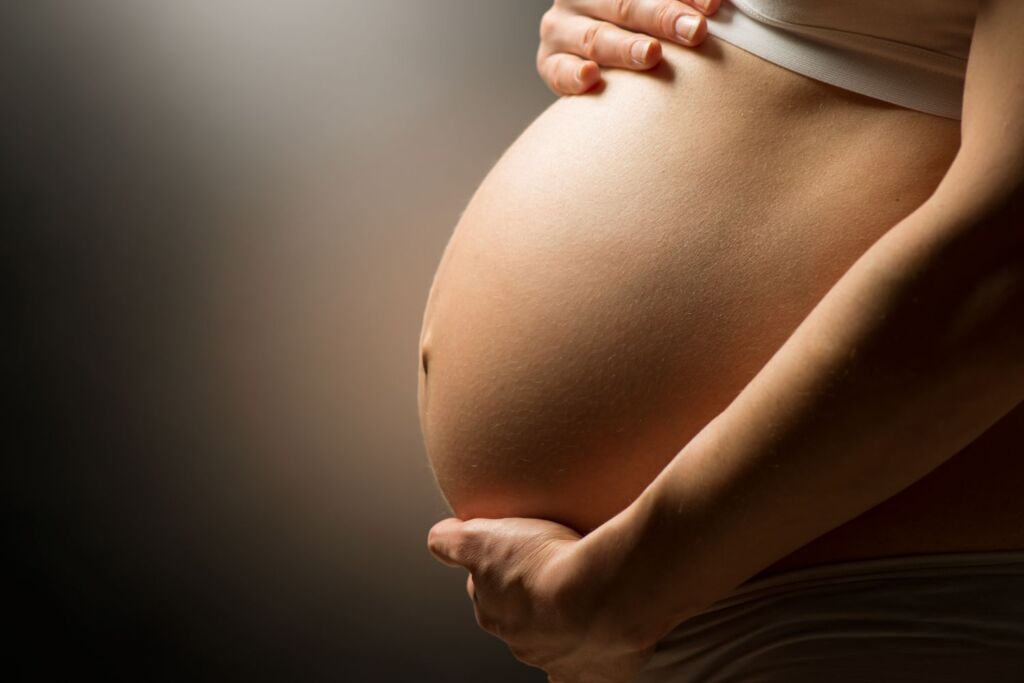 Frau hält sich Bauch in der Schwangerschaft
